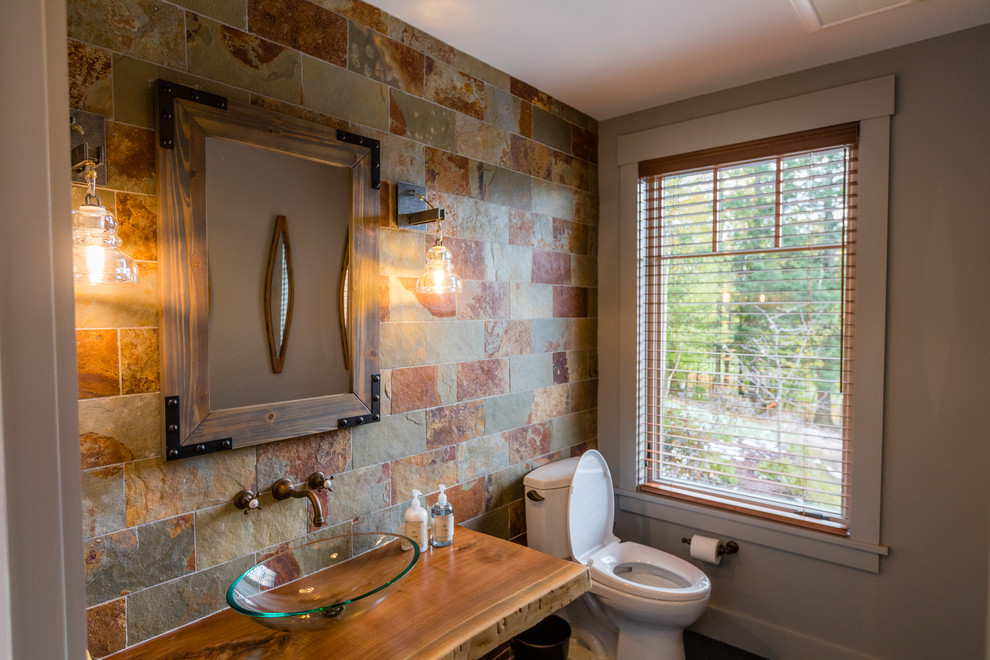 Idéer för ett rustikt brun badrum, med öppna hyllor, skåp i mellenmörkt trä, flerfärgad kakel, stenkakel, grå väggar, skiffergolv, ett fristående handfat, träbänkskiva och svart golv