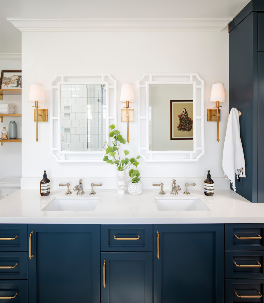 Свежая идея для дизайна: главная ванная комната среднего размера с фасадами в стиле шейкер, синими фасадами, отдельно стоящей ванной, угловым душем, унитазом-моноблоком, белой плиткой, керамической плиткой, белыми стенами, мраморным полом, врезной раковиной, столешницей из искусственного кварца, серым полом, душем с распашными дверями и белой столешницей - отличное фото интерьера