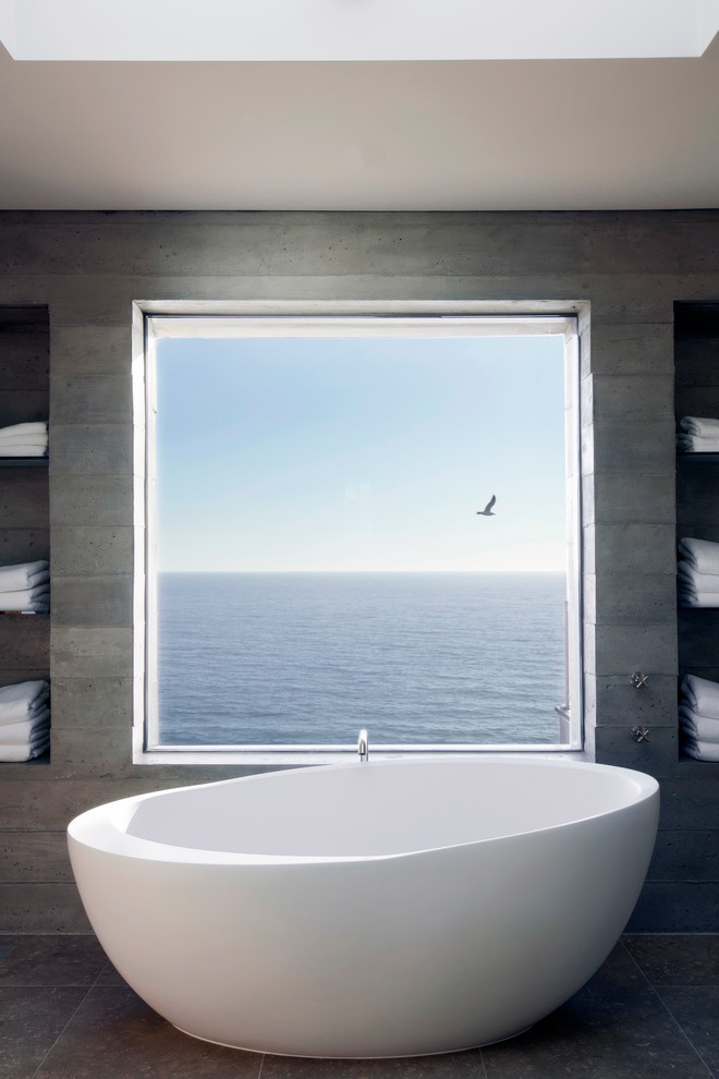Идея дизайна: большая главная ванная комната в морском стиле с отдельно стоящей ванной, цементной плиткой, серыми стенами, полом из известняка и бежевым полом