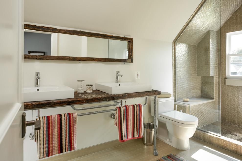 Inspiration för industriella badrum, med ett fristående handfat, träbänkskiva, en dusch i en alkov, en toalettstol med hel cisternkåpa, beige kakel och mosaik