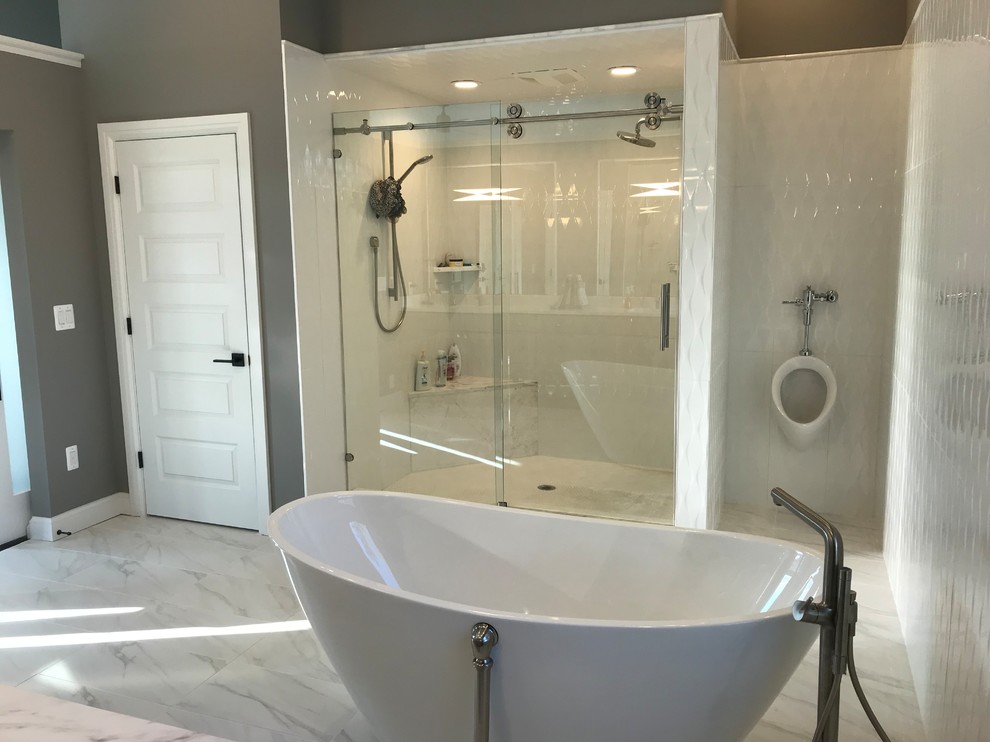 Exempel på ett mycket stort klassiskt en-suite badrum, med luckor med upphöjd panel, vita skåp, ett fristående badkar, en dusch i en alkov, ett urinoar, vit kakel, porslinskakel, vita väggar, marmorgolv, ett undermonterad handfat, granitbänkskiva, vitt golv och dusch med skjutdörr