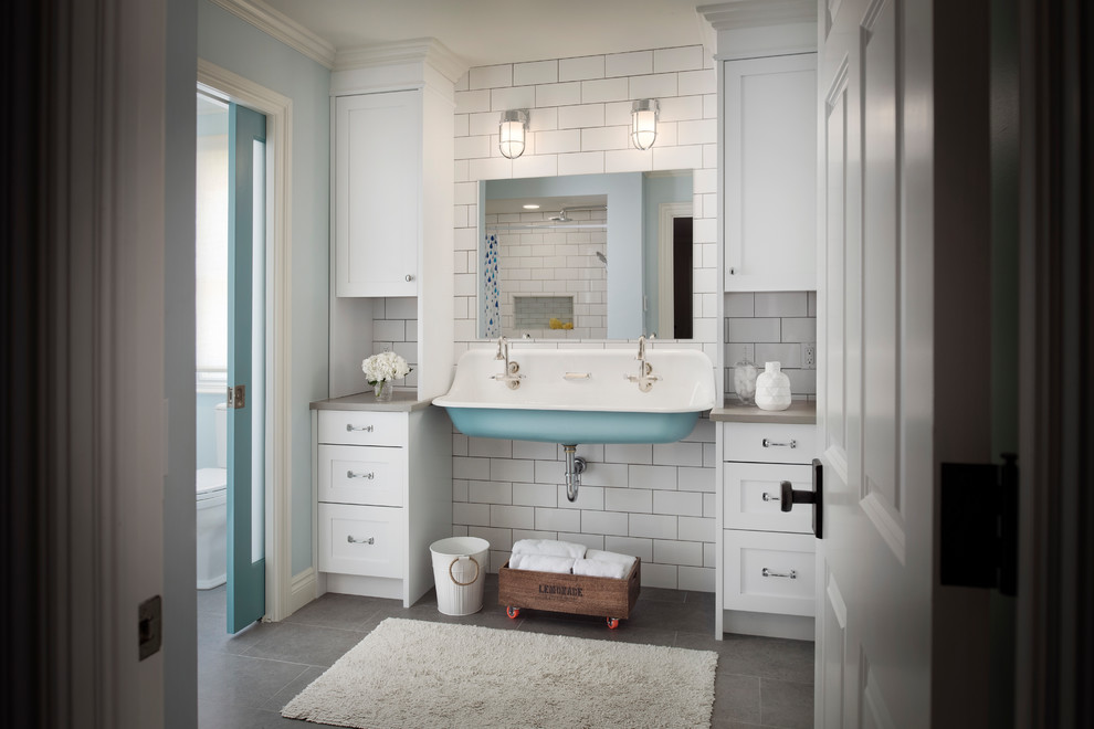 Klassisk inredning av ett mellanstort grå grått badrum med dusch, med skåp i shakerstil, vita skåp, vit kakel, blå väggar, ett avlångt handfat, grått golv, en dusch i en alkov, tunnelbanekakel och klinkergolv i porslin