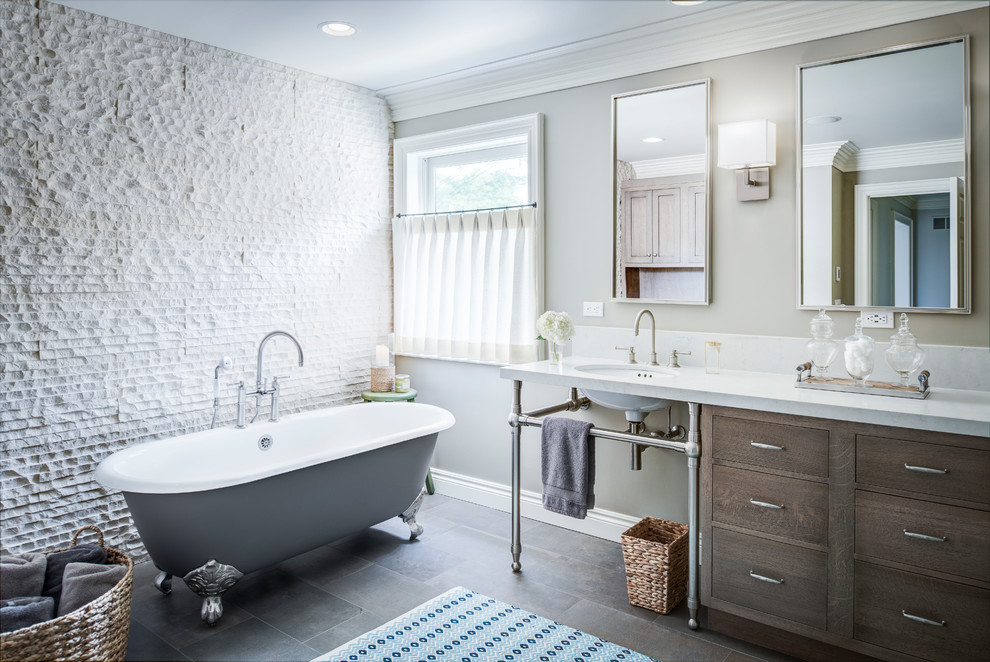 Large traditional ensuite bathroom in Detroit with flat-panel cabinets, dark wood cabinets, a claw-foot bath, white tiles, stone tiles, a submerged sink, white worktops, an alcove shower, beige walls, porcelain flooring, engineered stone worktops, brown floors, a hinged door and a feature wall.