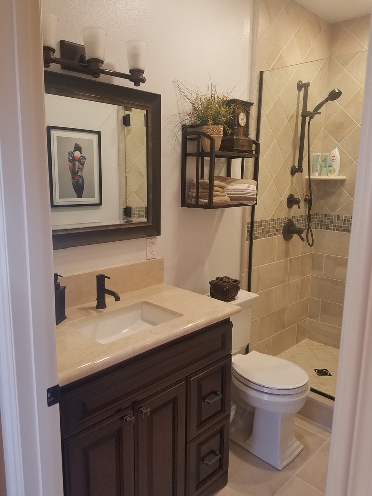 Design ideas for a medium sized mediterranean shower room bathroom in Los Angeles with raised-panel cabinets, black cabinets, an alcove shower, a two-piece toilet, beige tiles, travertine tiles, white walls, travertine flooring, a submerged sink, limestone worktops, beige floors and a hinged door.