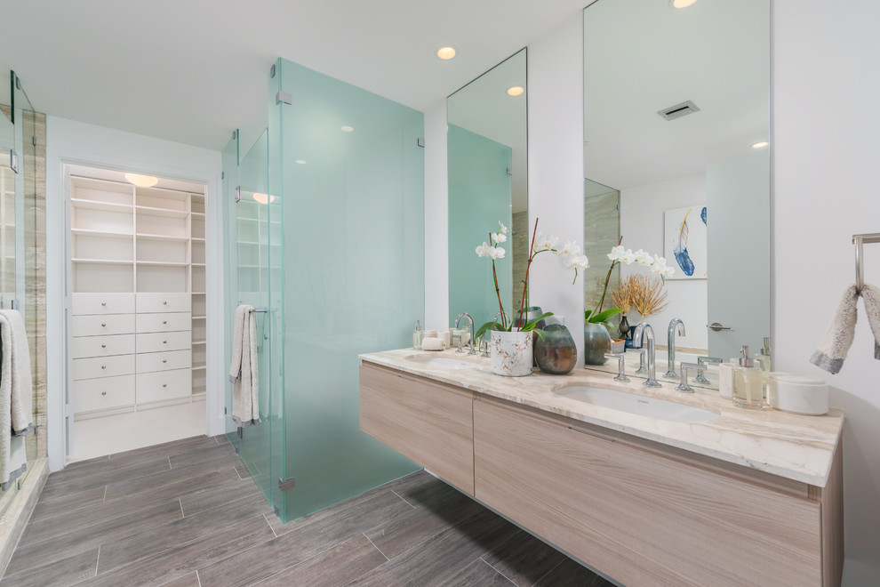 На фото: главная ванная комната в современном стиле с плоскими фасадами, светлыми деревянными фасадами, душевой комнатой, белыми стенами, врезной раковиной, коричневым полом и душем с распашными дверями