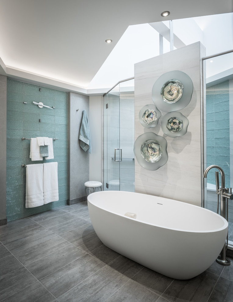 Design ideas for a contemporary ensuite bathroom in Other with freestanding cabinets, turquoise cabinets, a freestanding bath, a double shower, a one-piece toilet, green tiles, glass tiles, grey walls, ceramic flooring, a submerged sink, engineered stone worktops, grey floors and a hinged door.