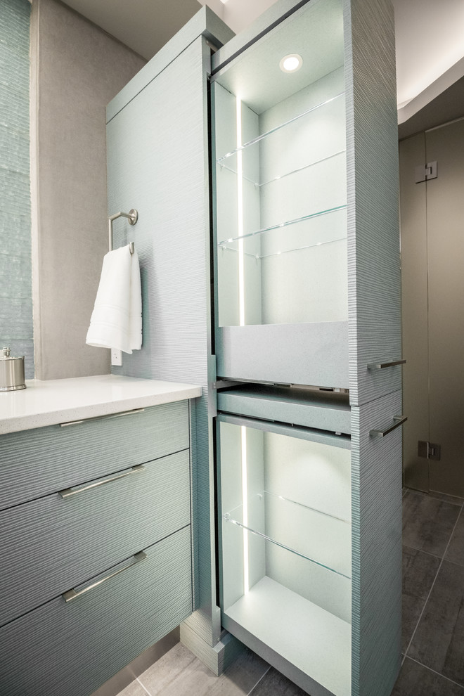 Пример оригинального дизайна: главная ванная комната в современном стиле с фасадами островного типа, бирюзовыми фасадами, отдельно стоящей ванной, двойным душем, унитазом-моноблоком, зеленой плиткой, стеклянной плиткой, серыми стенами, полом из керамической плитки, врезной раковиной, столешницей из искусственного кварца, серым полом и душем с распашными дверями