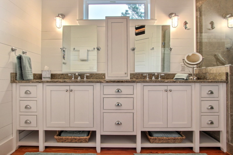 Imagen de cuarto de baño marinero con armarios con rebordes decorativos, puertas de armario blancas, encimera de piedra caliza, paredes blancas y suelo de madera clara