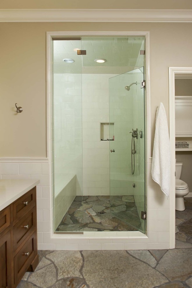 Immagine di una stanza da bagno boho chic con ante in stile shaker, ante in legno bruno, doccia alcova e piastrelle in pietra