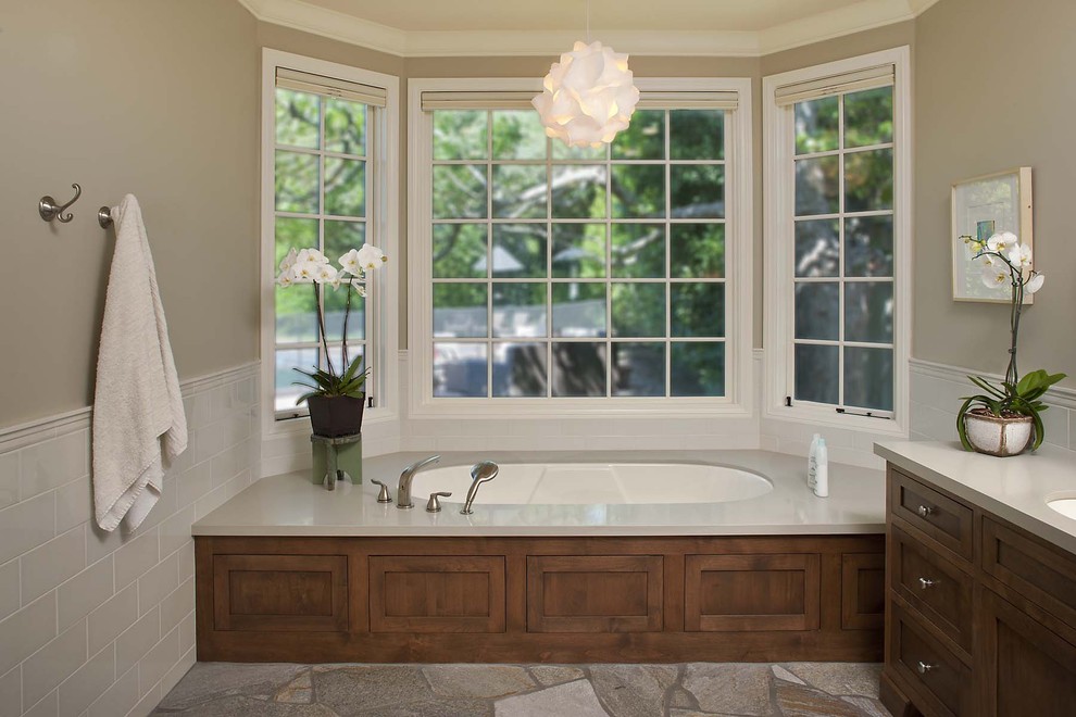 Idee per una stanza da bagno boho chic con ante in stile shaker, ante in legno scuro, vasca sottopiano, piastrelle beige e piastrelle in pietra