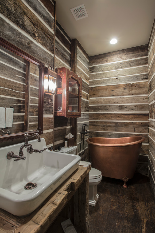 Свежая идея для дизайна: главная ванная комната в деревянном доме в стиле рустика с ванной на ножках, коричневыми стенами, темным паркетным полом, столешницей из дерева, коричневым полом и коричневой столешницей - отличное фото интерьера