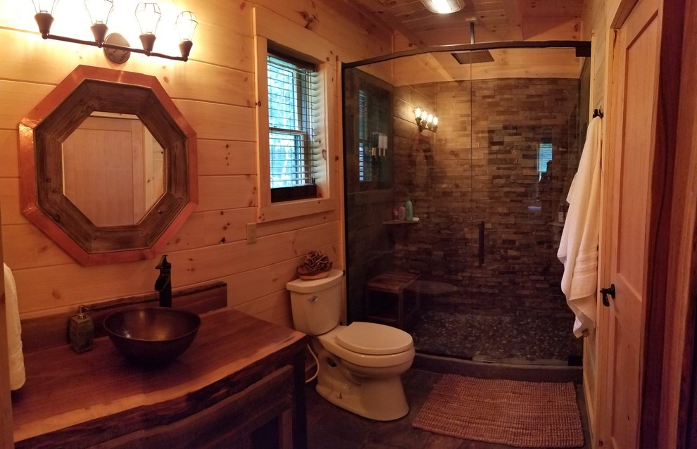 Inredning av ett rustikt en-suite badrum, med luckor med infälld panel, skåp i mellenmörkt trä, en öppen dusch, en toalettstol med hel cisternkåpa, flerfärgad kakel, skifferkakel, skiffergolv, ett fristående handfat, träbänkskiva, flerfärgat golv och dusch med gångjärnsdörr