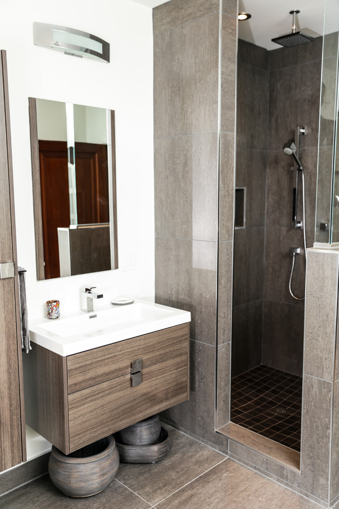 Modernes Badezimmer mit flächenbündigen Schrankfronten, grauen Fliesen, Keramikfliesen und hellen Holzschränken in Montreal