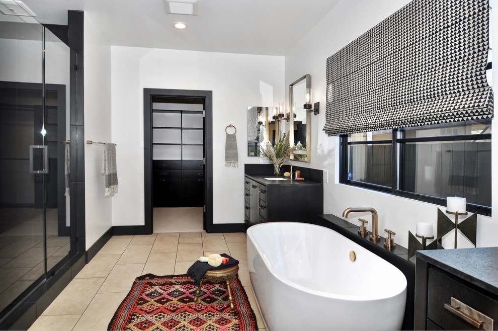 Bathroom - large transitional master black tile and marble tile limestone floor and beige floor bathroom idea in Orange County with flat-panel cabinets, black cabinets, a one-piece toilet, white walls, an undermount sink, granite countertops, a hinged shower door and black countertops