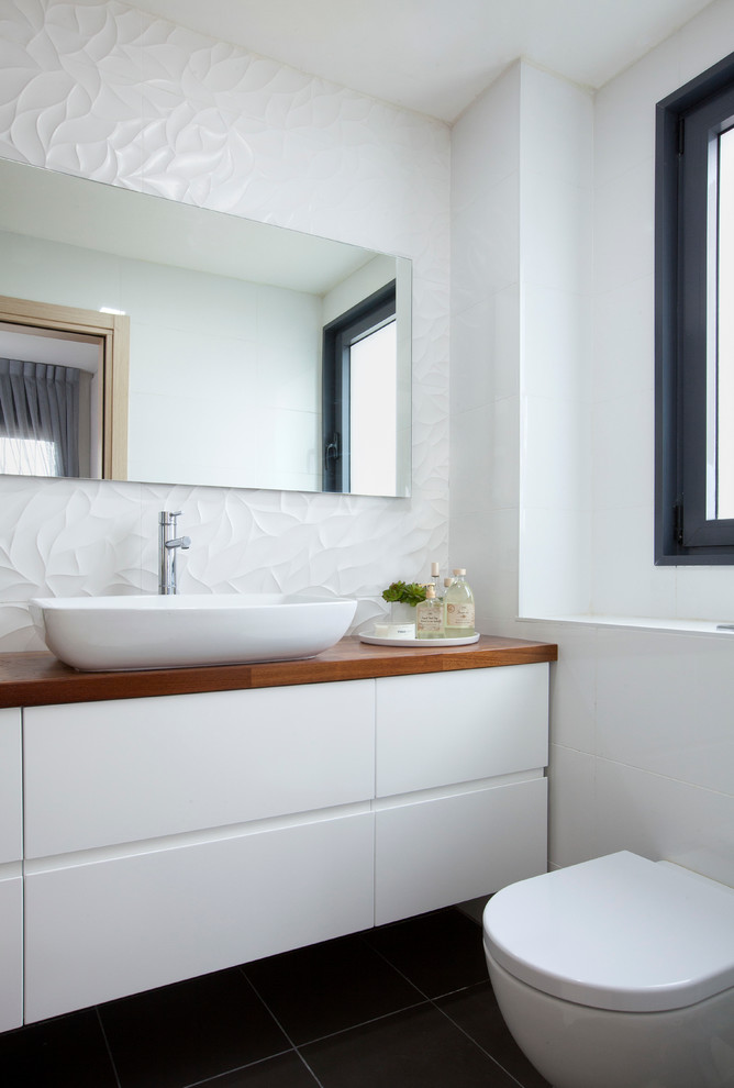 Idee per una stanza da bagno nordica con ante lisce, ante bianche, top in legno e piastrelle bianche