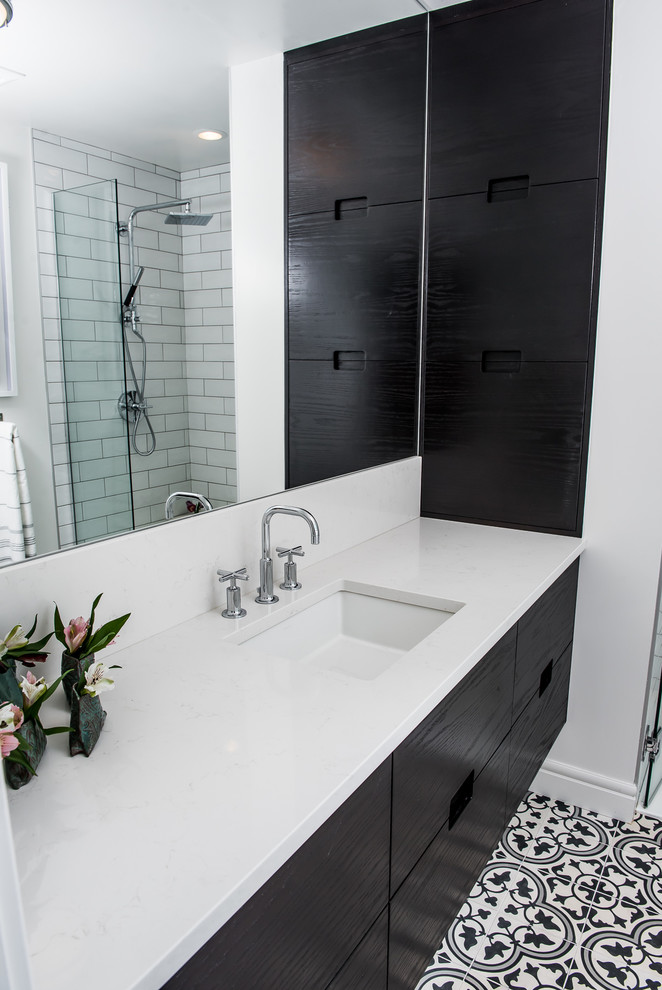 Idéer för mellanstora funkis en-suite badrum, med släta luckor, svarta skåp, en dusch i en alkov, en toalettstol med hel cisternkåpa, svart och vit kakel, cementkakel, vita väggar, cementgolv, ett undermonterad handfat och bänkskiva i kvartsit