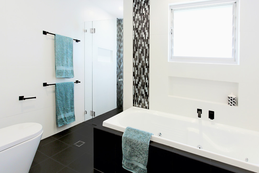Alcove shower - mid-sized contemporary master black and white tile and porcelain tile porcelain tile alcove shower idea in Sydney with flat-panel cabinets, dark wood cabinets, a hot tub, white walls, an integrated sink and solid surface countertops