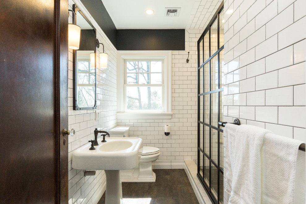 Foto på ett vintage badrum, med en dusch i en alkov, vit kakel, tunnelbanekakel, svarta väggar, ett piedestal handfat, grått golv och med dusch som är öppen