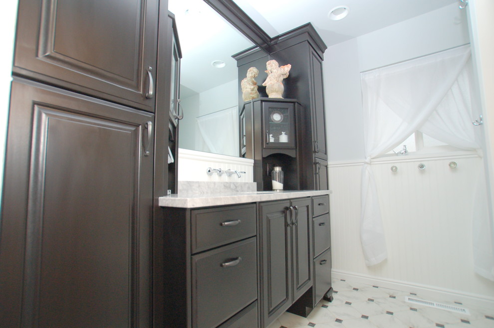 Small traditional shower room bathroom in Boise with a submerged sink, raised-panel cabinets, black cabinets, marble worktops, an alcove bath, a shower/bath combination, a two-piece toilet, grey walls and lino flooring.