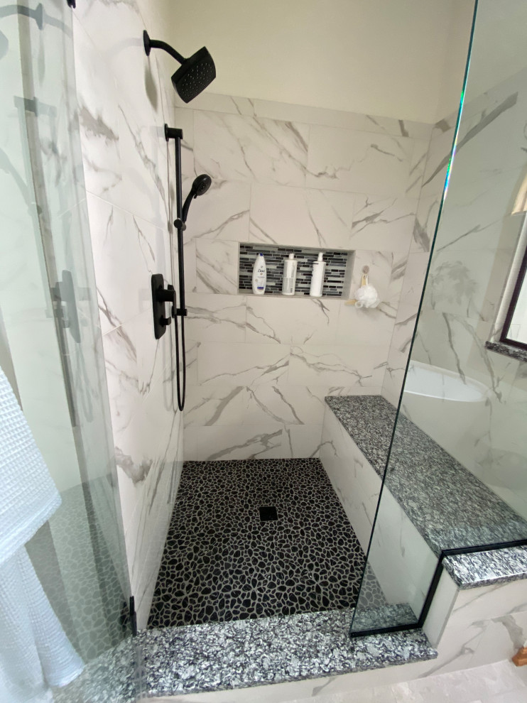 Inspiration för ett stort nordiskt svart svart en-suite badrum, med luckor med upphöjd panel, svarta skåp, ett fristående badkar, en dusch i en alkov, en toalettstol med separat cisternkåpa, vit kakel, porslinskakel, grå väggar, klinkergolv i porslin, ett undermonterad handfat, granitbänkskiva, grått golv och dusch med gångjärnsdörr