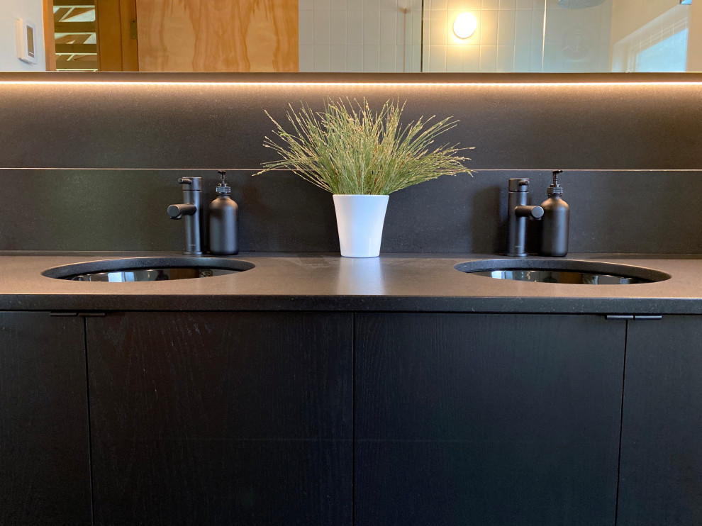 Photo of a medium sized modern shower room bathroom in Seattle with flat-panel cabinets, black cabinets, white tiles, ceramic tiles, white walls, porcelain flooring, a submerged sink, granite worktops, black floors, black worktops, double sinks, a built in vanity unit and a vaulted ceiling.