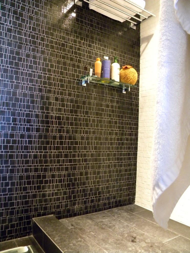 На фото: большая главная ванная комната в стиле модернизм с душем в нише, черно-белой плиткой, стеклянной плиткой и черными стенами