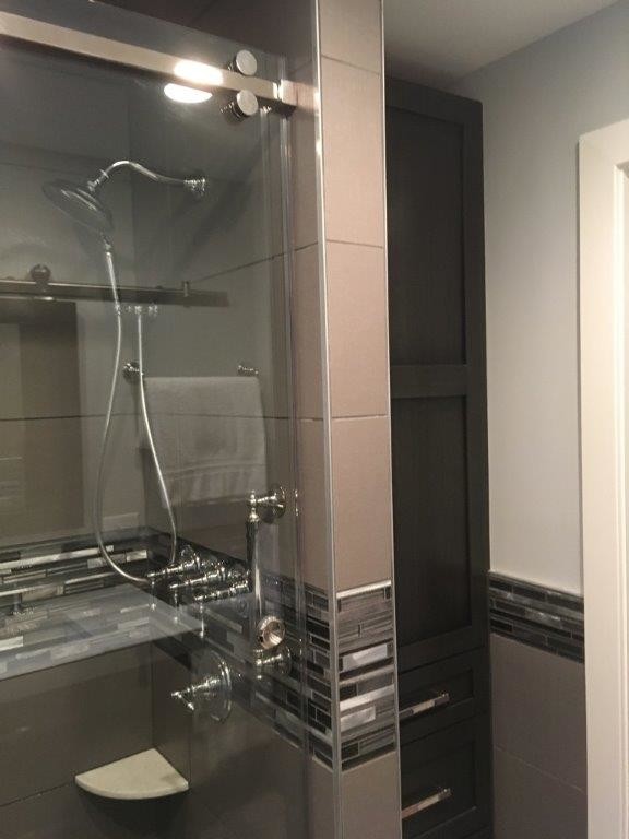 This is an example of a small contemporary shower room bathroom in Philadelphia with freestanding cabinets, black cabinets, an alcove shower, a two-piece toilet, black tiles, black and white tiles, grey tiles, ceramic tiles, grey walls, porcelain flooring, a submerged sink, engineered stone worktops, beige floors and a sliding door.
