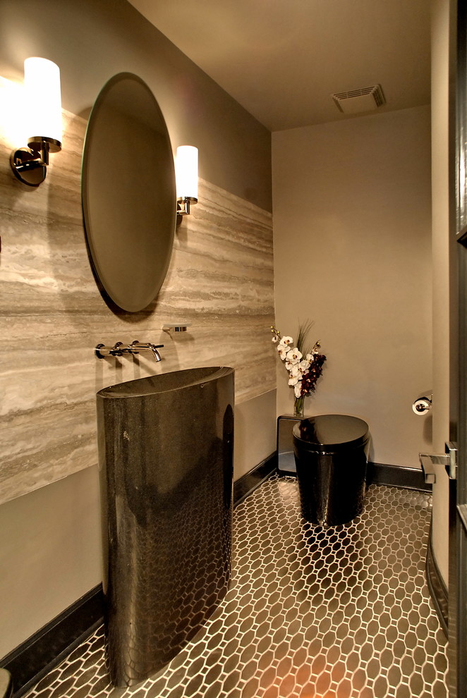 Modern inredning av ett badrum, med ett piedestal handfat, en toalettstol med hel cisternkåpa, kakel i metall, grå väggar och mosaikgolv
