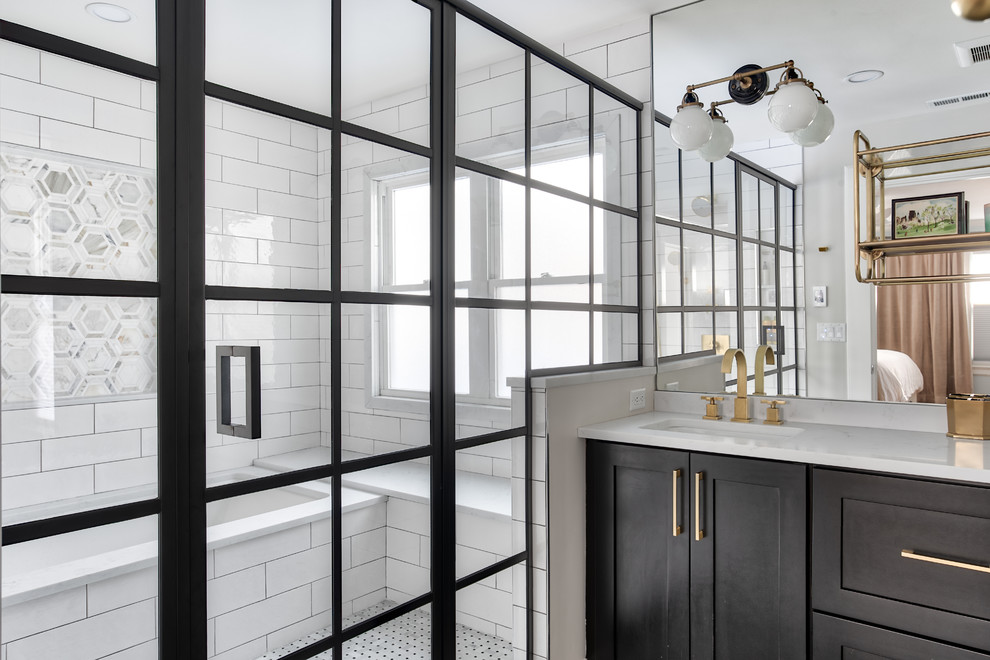 Inspiration for a large modern ensuite bathroom in New York with shaker cabinets, black cabinets, a submerged bath, a shower/bath combination, a one-piece toilet, white tiles, metro tiles, white walls, mosaic tile flooring, a submerged sink, a hinged door and white worktops.