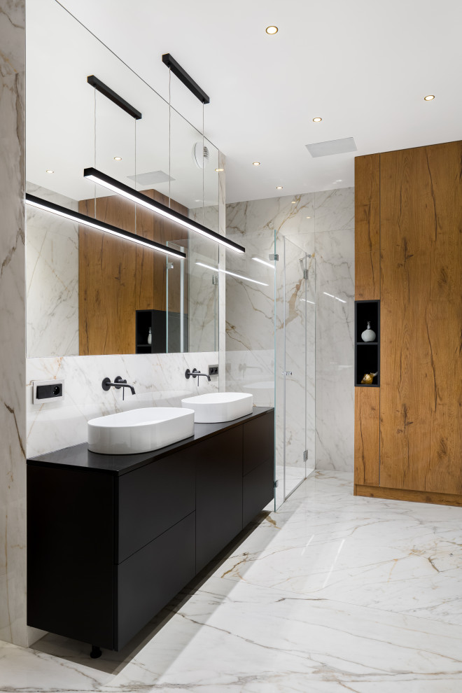 Идея дизайна: ванная комната среднего размера в современном стиле с плоскими фасадами, черными фасадами, отдельно стоящей ванной, черно-белой плиткой, мраморной плиткой, белыми стенами, мраморным полом, настольной раковиной, белым полом, нишей, тумбой под две раковины и встроенной тумбой