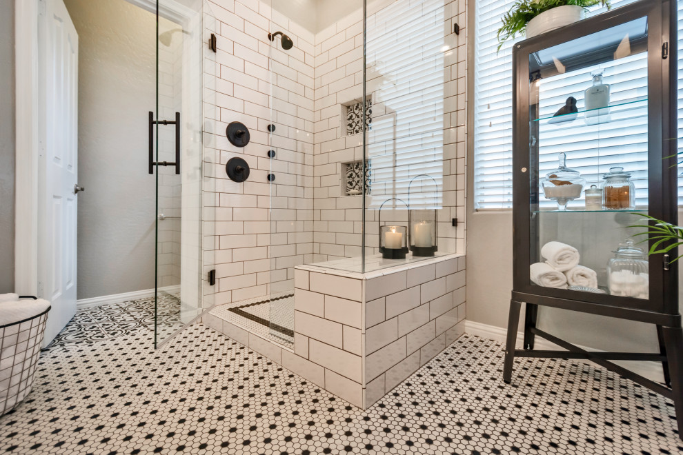 Example of a mid-sized transitional master white tile and subway tile mosaic tile floor and white floor corner shower design in Phoenix with shaker cabinets, white cabinets, gray walls, an undermount sink, granite countertops, a hinged shower door and black countertops