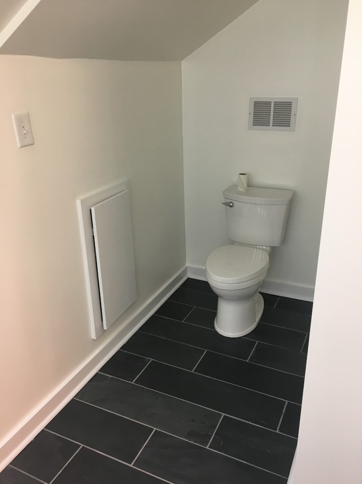 This is an example of a large modern ensuite bathroom in Charlotte with an alcove shower, a two-piece toilet, white tiles, metro tiles, slate flooring, an integrated sink, black floors, a hinged door, flat-panel cabinets, white cabinets, white walls, glass worktops and white worktops.