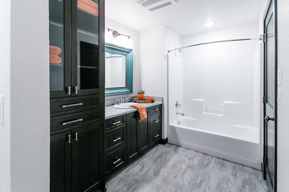 Design ideas for a medium sized classic bathroom in Other with shaker cabinets, black cabinets, an alcove bath, a shower/bath combination, white walls, porcelain flooring, a built-in sink, grey floors and a shower curtain.