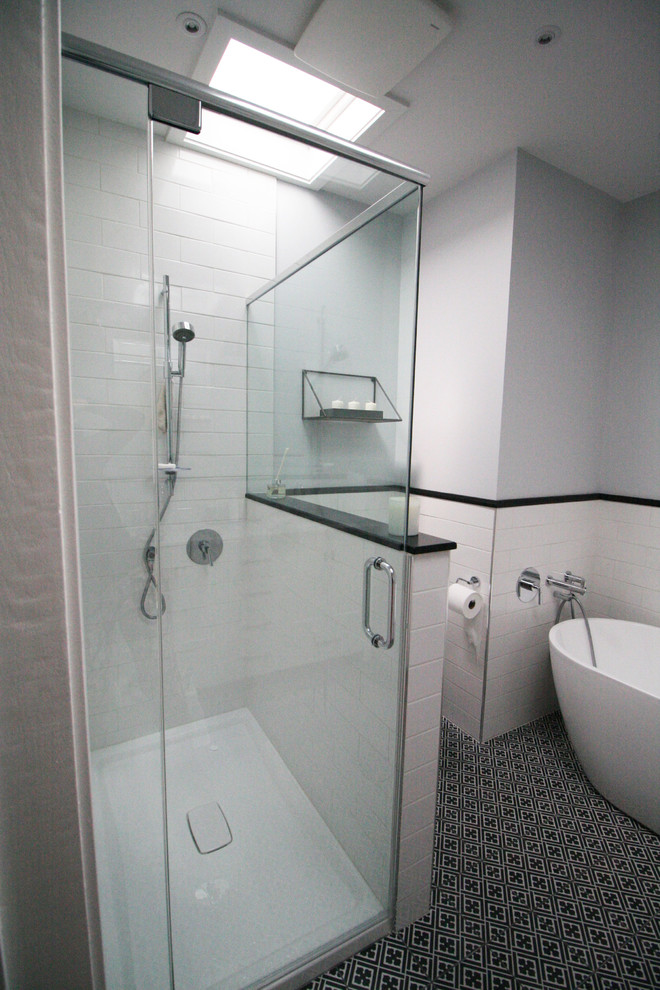 Example of a mid-sized transitional master white tile and ceramic tile cement tile floor and black floor bathroom design in Montreal with shaker cabinets, white cabinets, a one-piece toilet, gray walls, an undermount sink, marble countertops, a hinged shower door and gray countertops