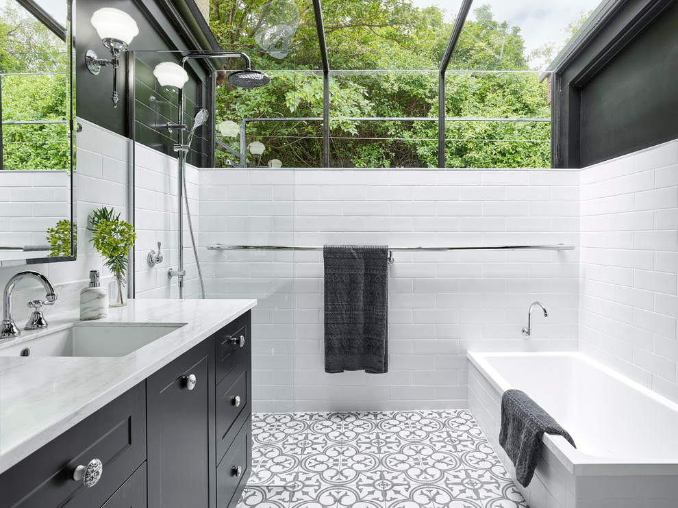 Klassisk inredning av ett mellanstort vit vitt en-suite badrum, med svarta skåp, ett platsbyggt badkar, en öppen dusch, svart och vit kakel, vita väggar, klinkergolv i porslin, ett undermonterad handfat, bänkskiva i akrylsten, med dusch som är öppen, skåp i shakerstil, keramikplattor och flerfärgat golv