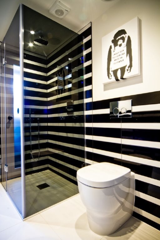 Cette image montre une petite salle de bain principale bohème en bois foncé avec un lavabo suspendu, une baignoire posée, une douche d'angle, WC suspendus, un carrelage noir et blanc, des carreaux de céramique, un mur blanc et un sol en carrelage de porcelaine.