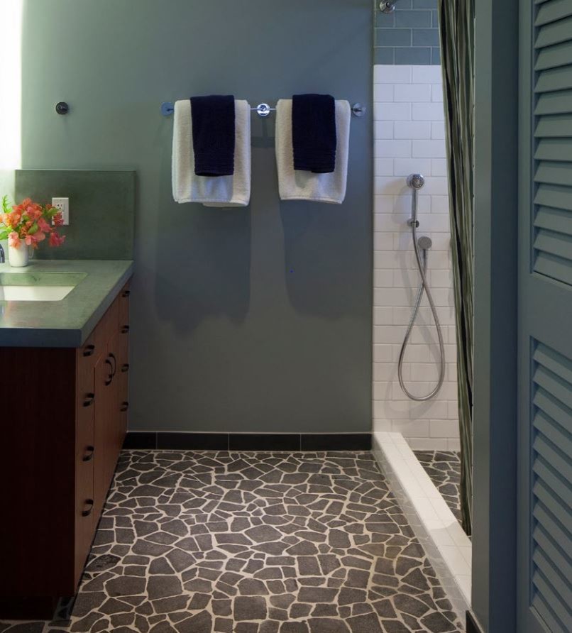 На фото: большая главная ванная комната с плоскими фасадами, темными деревянными фасадами, открытым душем, серой плиткой, каменной плиткой, синими стенами, полом из галечной плитки и монолитной раковиной с