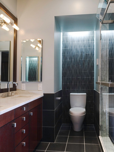 Example of a trendy black tile and porcelain tile porcelain tile bathroom design in Boston with an undermount sink, flat-panel cabinets, dark wood cabinets, marble countertops and a two-piece toilet