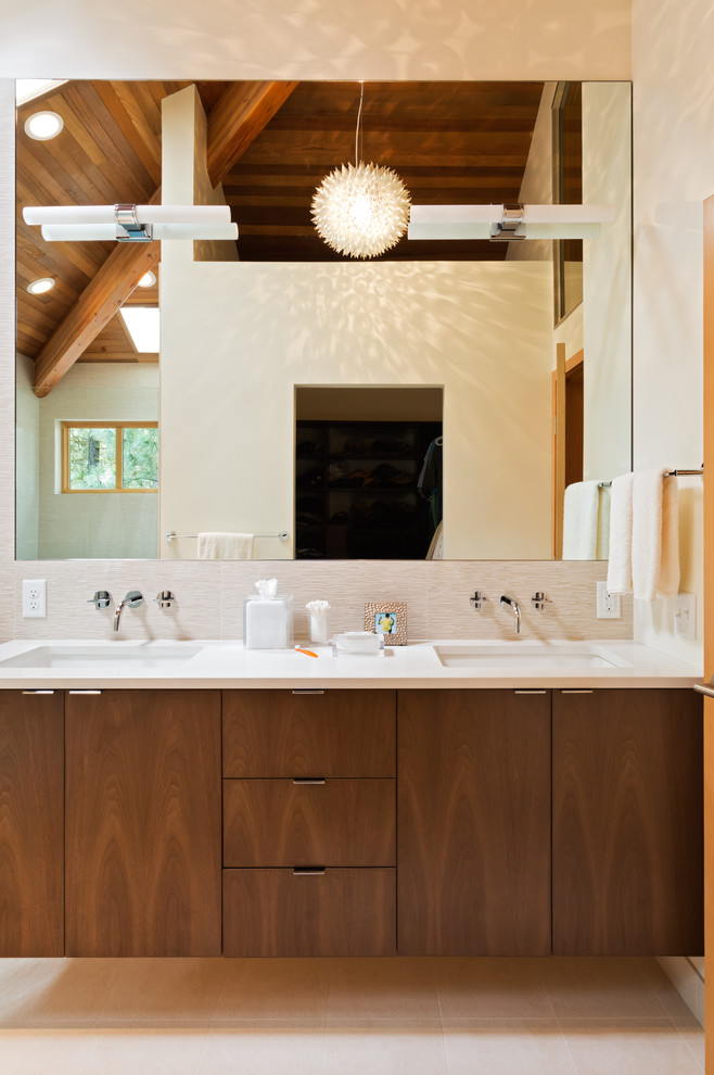 Стильный дизайн: ванная комната: освещение в стиле модернизм с врезной раковиной, плоскими фасадами, темными деревянными фасадами и бежевой плиткой - последний тренд