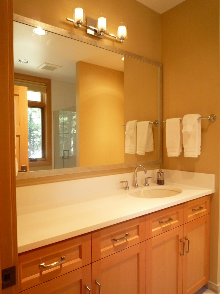 Aménagement d'une grande douche en alcôve principale montagne en bois clair avec un placard à porte shaker, un mur beige, un lavabo encastré et un plan de toilette en quartz modifié.