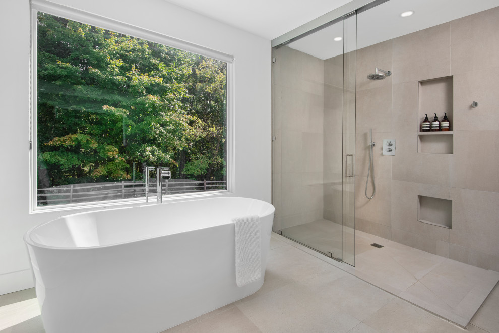 Inredning av ett modernt stort en-suite badrum, med ett fristående badkar, en kantlös dusch, grå kakel, vita väggar, beiget golv, dusch med skjutdörr, porslinskakel och klinkergolv i porslin