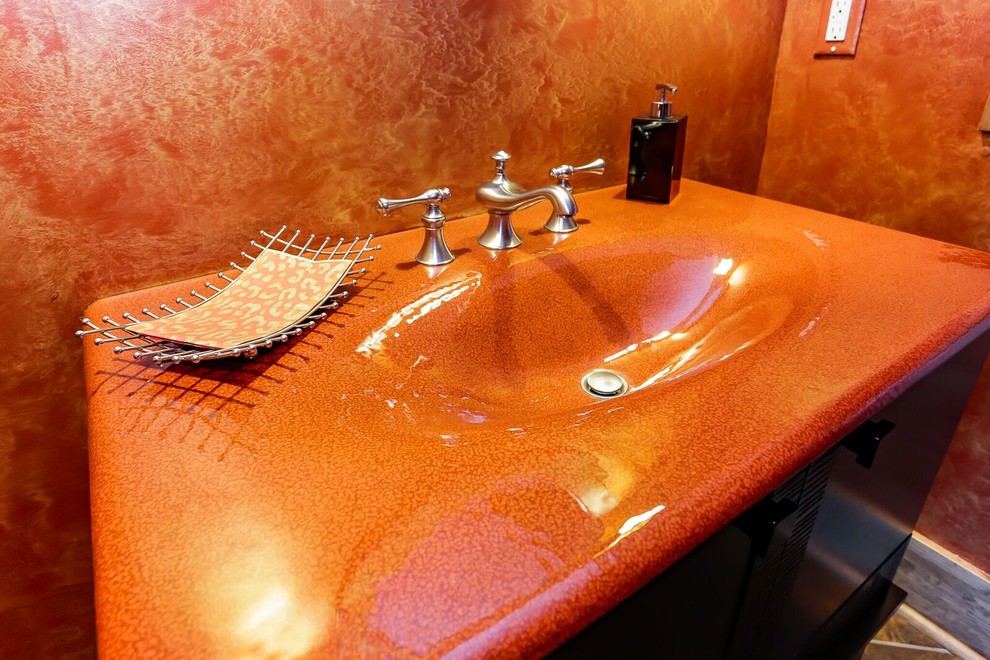 Idée de décoration pour une salle d'eau craftsman en bois foncé de taille moyenne avec un placard à porte plane, un mur orange, un sol en carrelage de céramique et un lavabo posé.