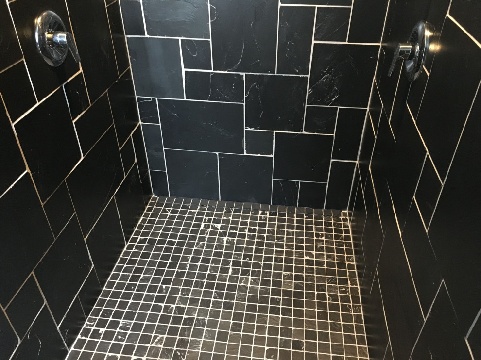Exemple d'une salle de bain tendance avec une douche à l'italienne, un carrelage noir, un carrelage de pierre, un sol en ardoise, un lavabo suspendu et un sol noir.