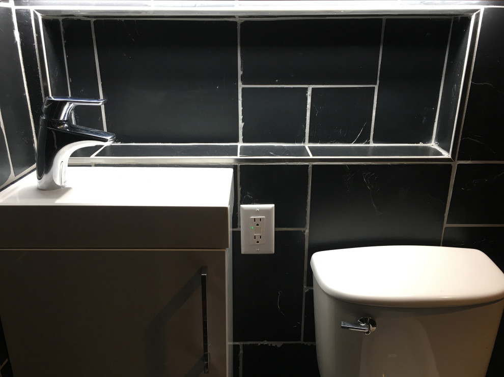 Esempio di una stanza da bagno design con doccia a filo pavimento, piastrelle nere, piastrelle in pietra, pavimento in ardesia, lavabo sospeso e pavimento nero