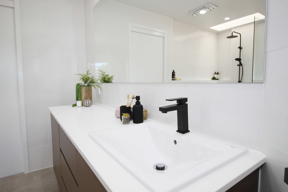 Large contemporary family bathroom in Brisbane with flat-panel cabinets, dark wood cabinets, a freestanding bath, a walk-in shower, white tiles, ceramic tiles, white walls, porcelain flooring, a built-in sink, engineered stone worktops, beige floors, an open shower and white worktops.