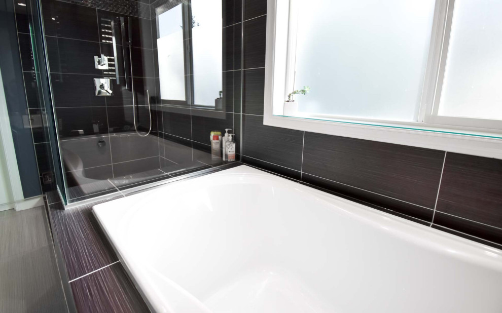 Aménagement d'une salle de bain principale moderne de taille moyenne avec une baignoire posée, une douche d'angle, un carrelage noir, des carreaux de céramique, un sol en carrelage de céramique, un sol beige et une cabine de douche à porte battante.