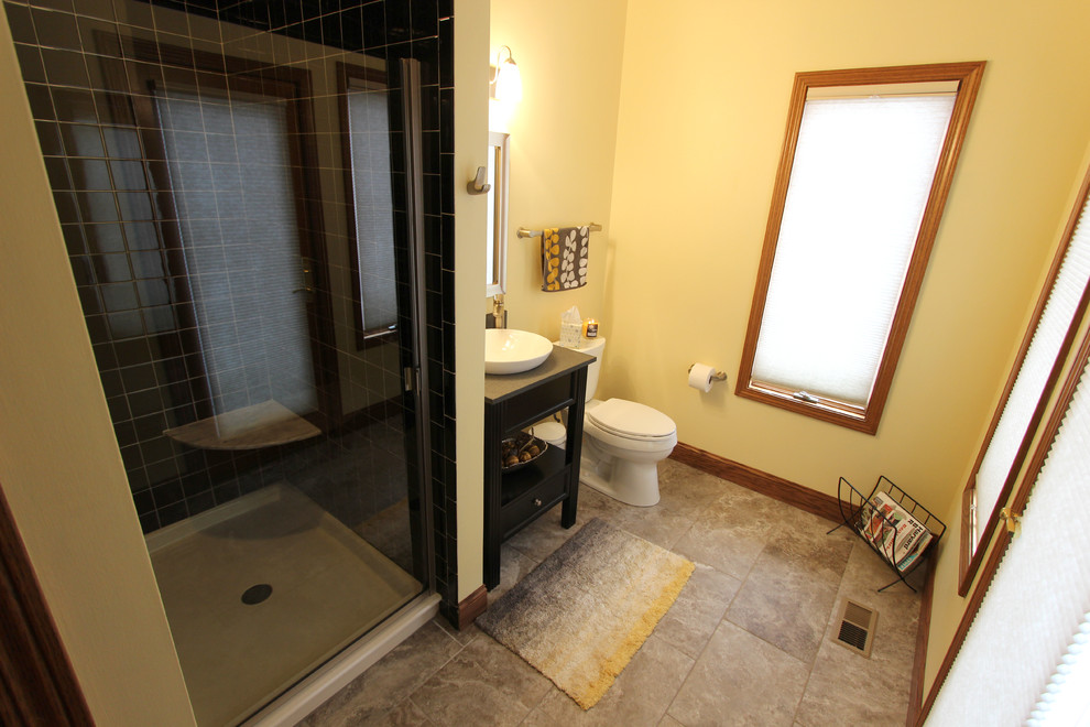 Inspiration för ett mellanstort vintage badrum, med ett fristående handfat, öppna hyllor, svarta skåp, en hörndusch, svart kakel, keramikplattor, gula väggar och klinkergolv i porslin
