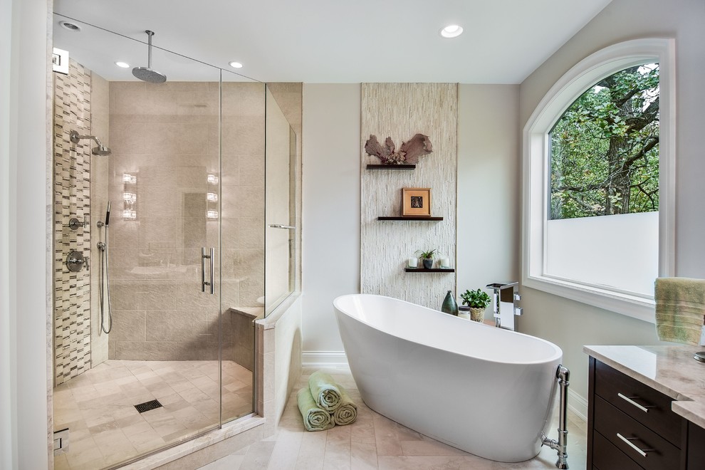Exemple d'une grande douche en alcôve principale tendance en bois foncé avec un placard à porte plane, des carreaux de porcelaine, une baignoire indépendante, un mur beige, une vasque et un plan de toilette en granite.