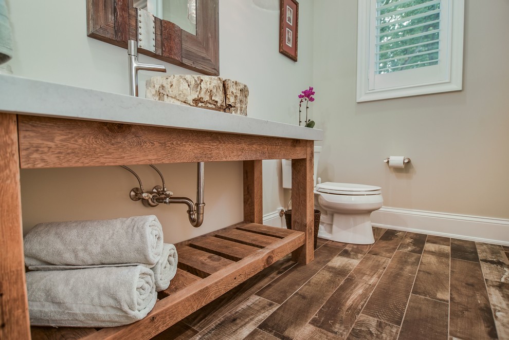 Idées déco pour une salle de bain principale montagne en bois brun de taille moyenne avec un placard sans porte, WC séparés, un mur beige, un sol en bois brun, une vasque et un plan de toilette en surface solide.