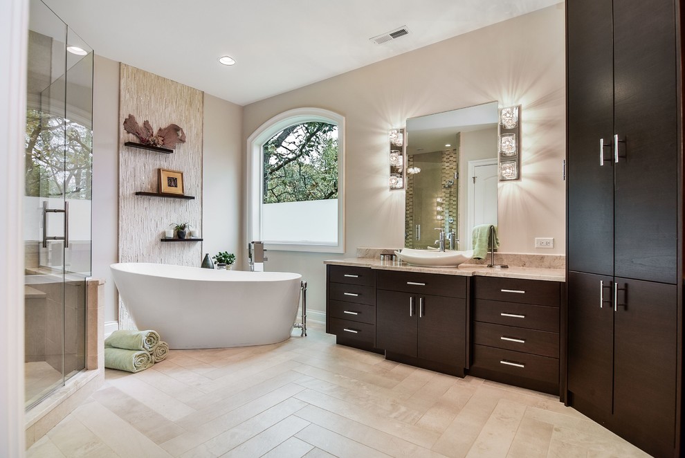 Inredning av ett modernt stort en-suite badrum, med släta luckor, skåp i mörkt trä, porslinskakel, ett fristående handfat, ett fristående badkar, en dusch i en alkov, beige väggar och granitbänkskiva